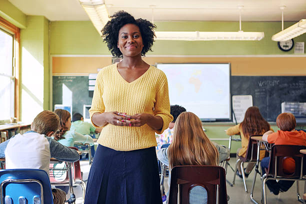 portrait of a young teacher with her learners in the background
